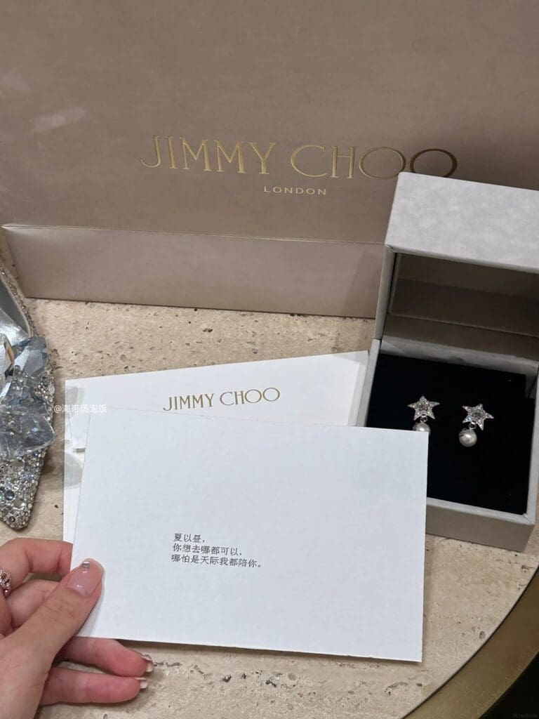 gift earrings and written card from jimmy choo with an image card showing a love and deepspace character, next to jimmy choo crystal shoe